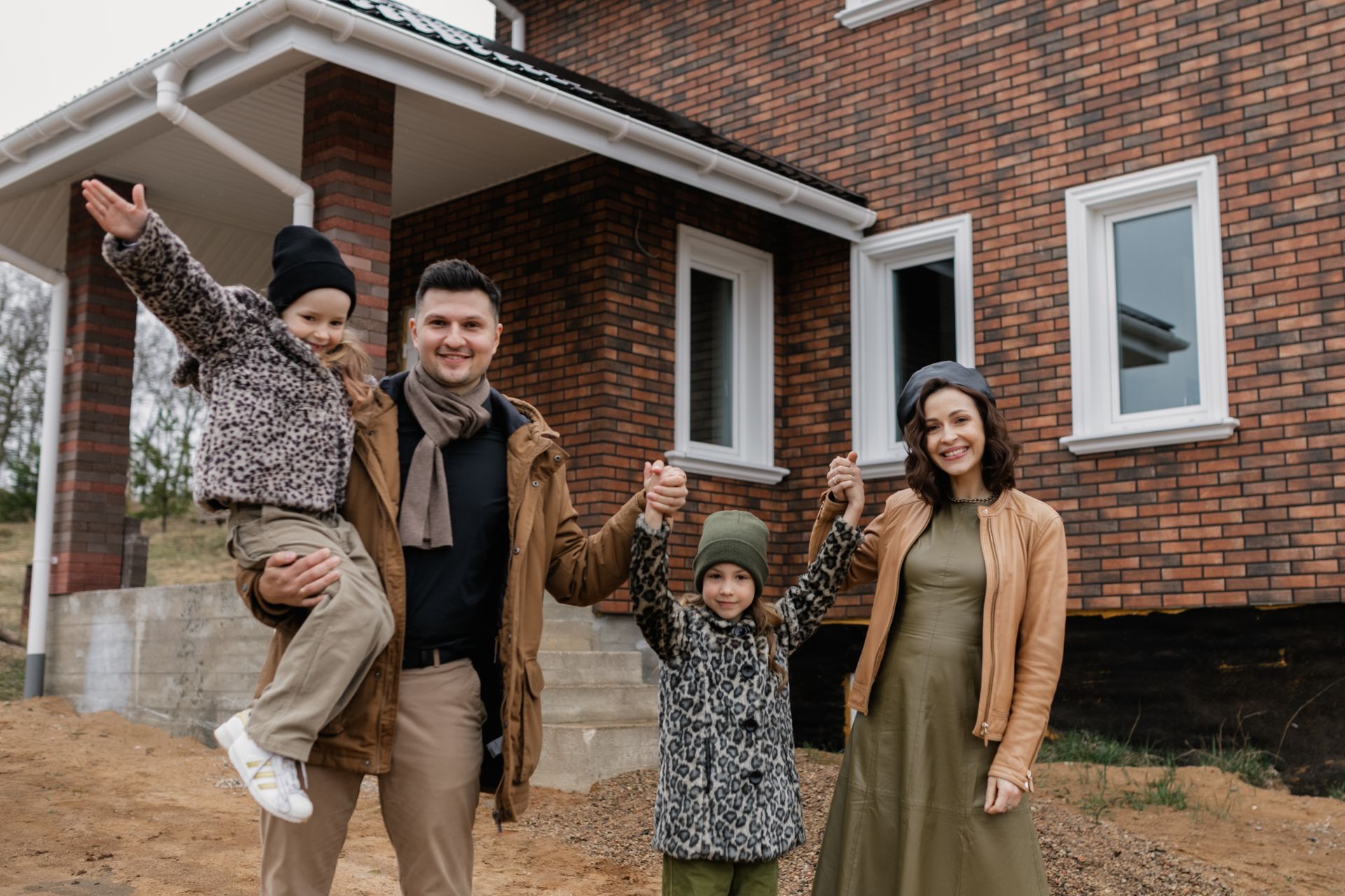 Happy family standing in front of their home powered by solar and battery backup